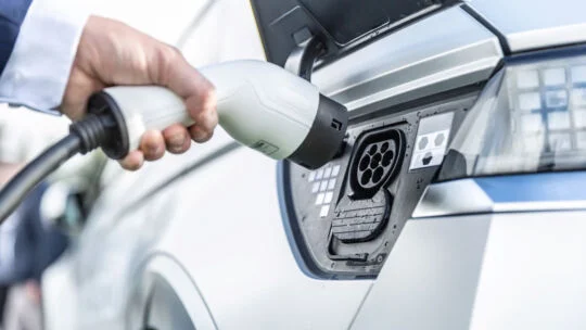 persona cargando un vehículo eléctrico
