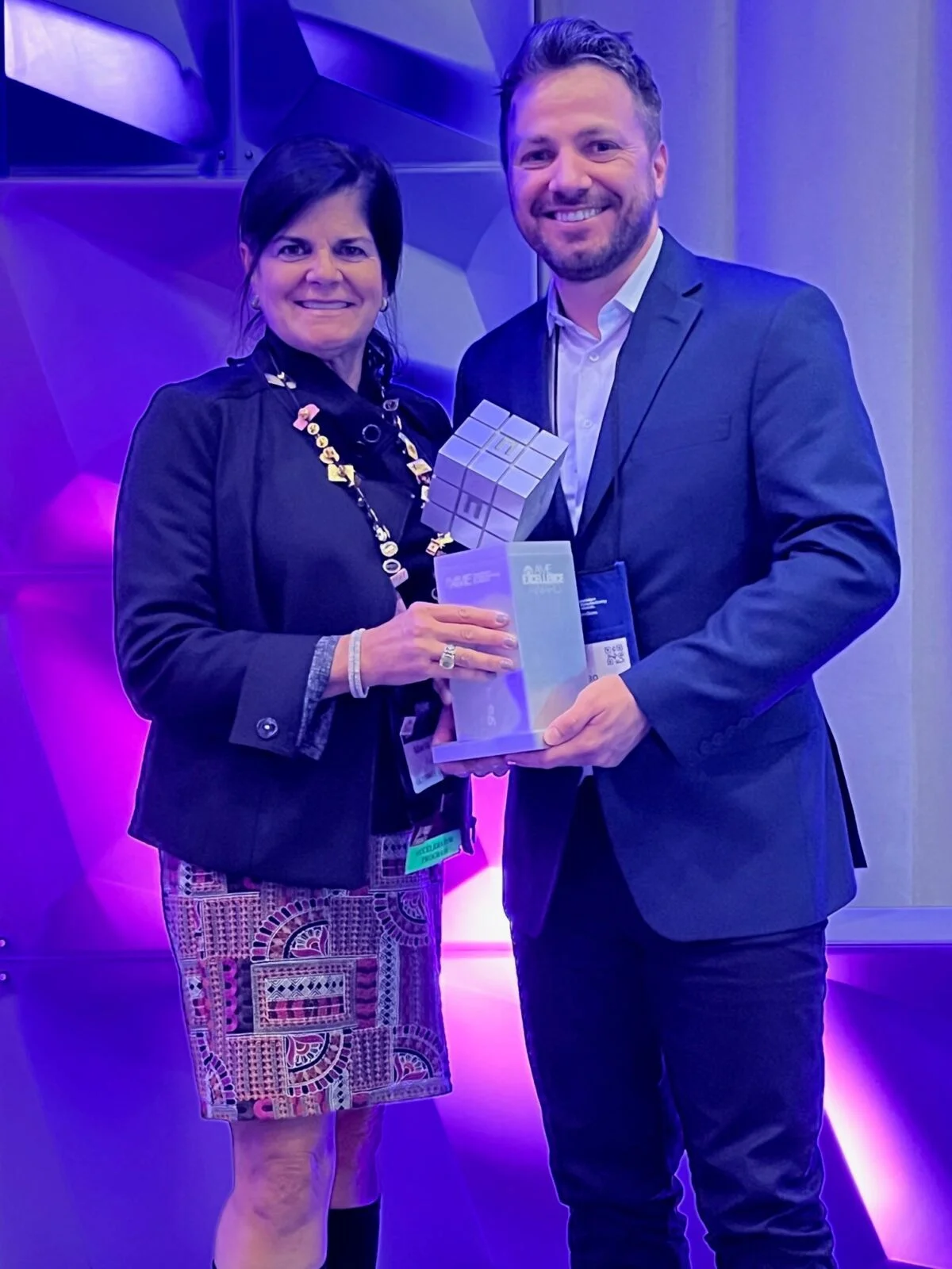 dos personas sosteniendo un premio entre ellos