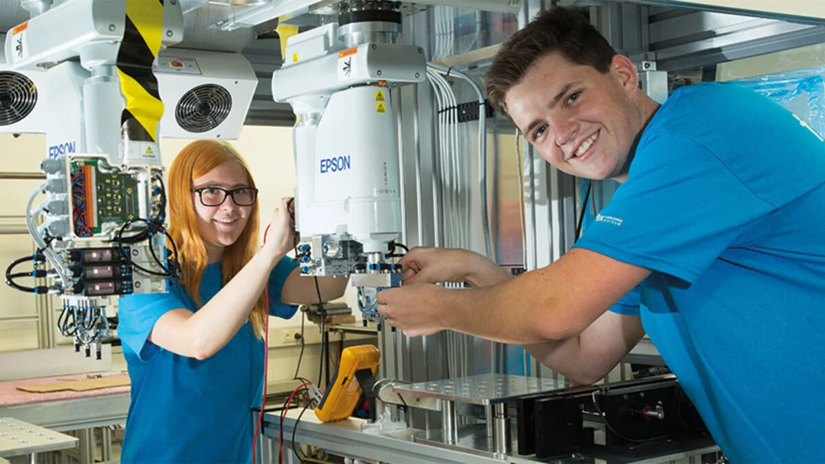 Dos aprendices trabajando en una máquina.