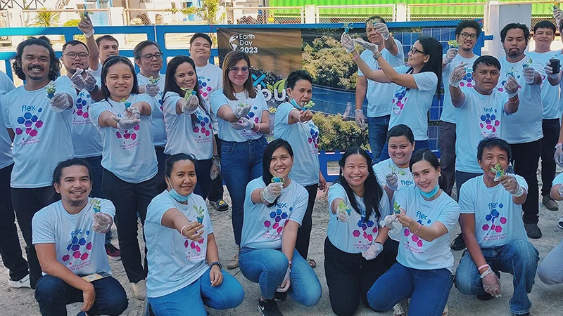 Empleados de Flex en Cebú, Filipinas, agrupados sosteniendo flores
