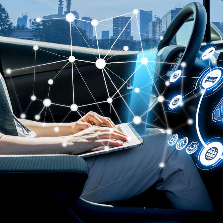 Persona que utiliza un dispositivo electrónico personal mientras viaja en un vehículo autónomo.
