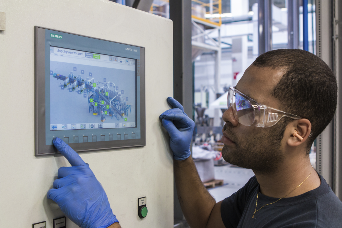 Fertigungsprofi, der einen Touchscreen zur Schnittstelle mit der Fabrikausrüstung verwendet